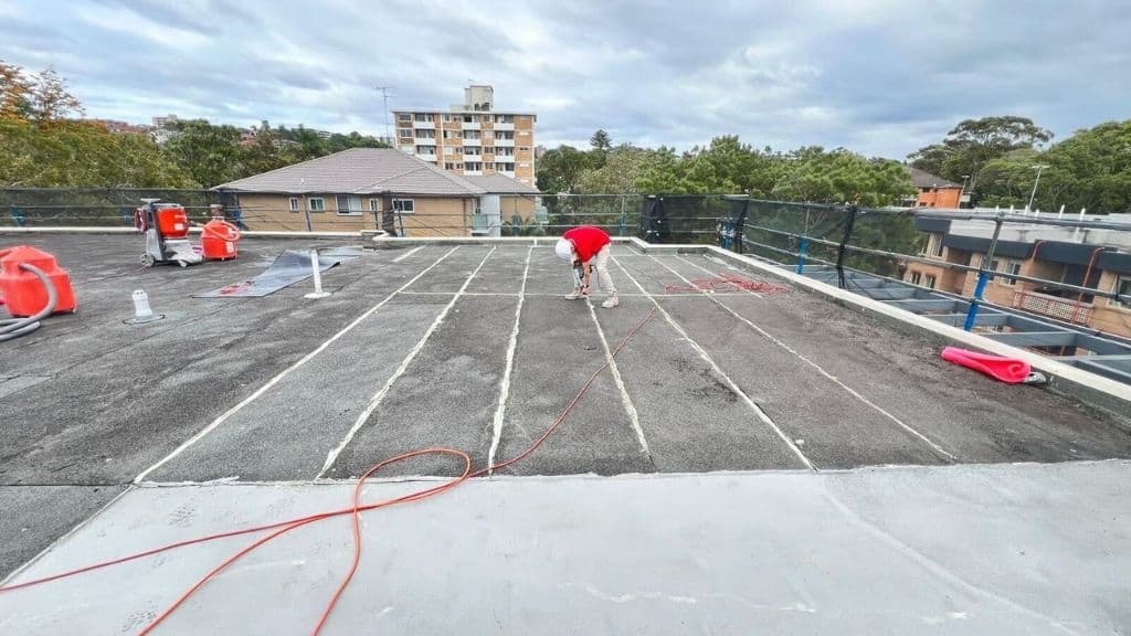 A man is removing waterproofing membrane on a roof.